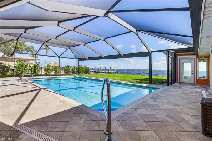 Large pool deck with new screen and Panoramic Screen view of the bay.  The French door leads to the sunroom.