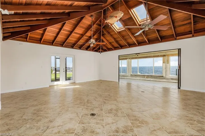 This beautiful open vault redwood ceiling has plenty of natural light with the sunroom and skylights, and the gorgeous bay views.  The French doors lead to the lanai and pool.