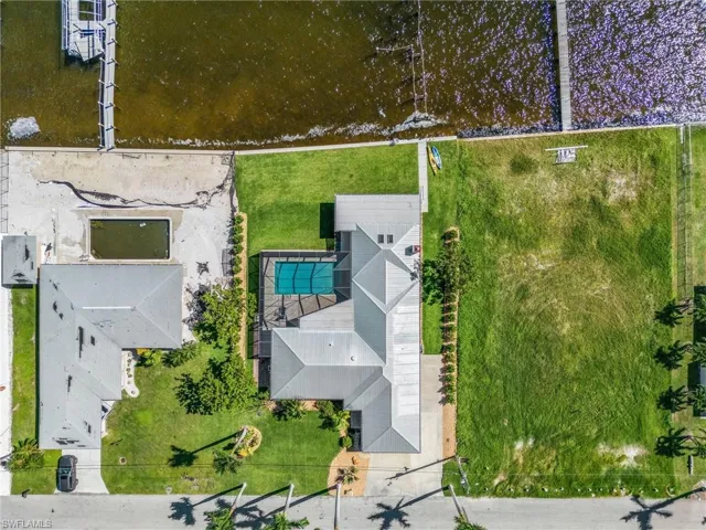 Aerial view of home with all new landscaping, new seawall (2021), plenty of parking, and move in ready!