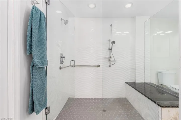 Enjoy this large walk in shower with bench and dual shower heads.