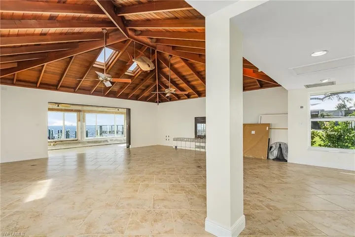 This large family/living room with wood burning fireplace, has beautiful bay views, and an open vault redwood ceiling.