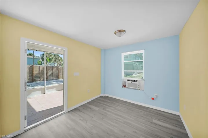 Unfurnished room with healthy amount of natural light, light wood-style flooring, and cooling unit