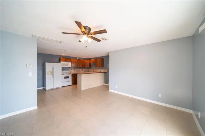 Unfurnished living room with a ceiling fan and light tile patterned flooring