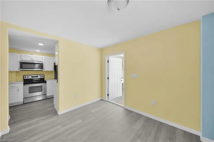 Kitchen featuring stainless steel appliances, white cabinets, recessed lighting, light countertops, and light wood-style flooring