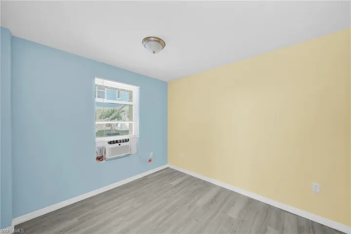 Spare room featuring light wood-style floors and cooling unit
