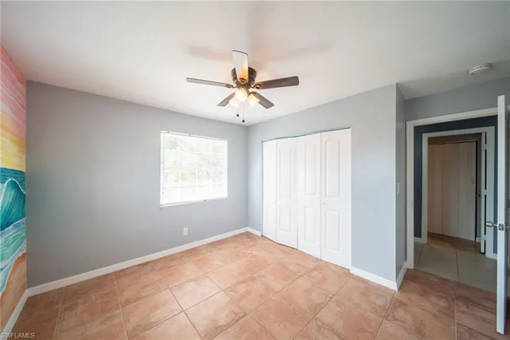 Unfurnished bedroom with a closet, a ceiling fan, and light tile patterned floors