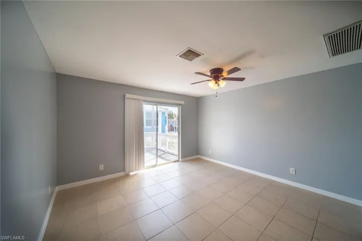 Spare room featuring ceiling fan and light tile patterned floors
