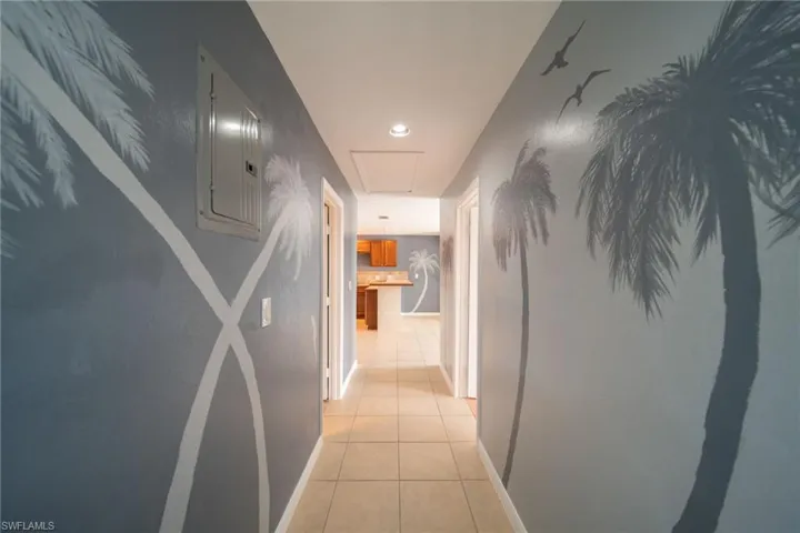 Hallway with light tile patterned flooring, electric panel, and recessed lighting