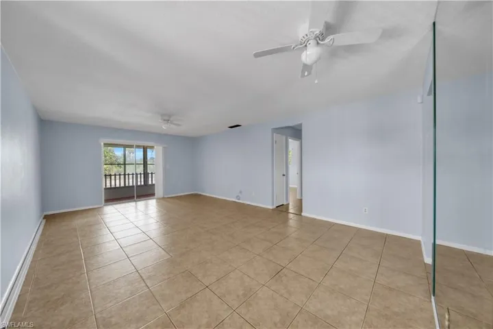 Spare room featuring ceiling fan, light tile patterned floors, and baseboards