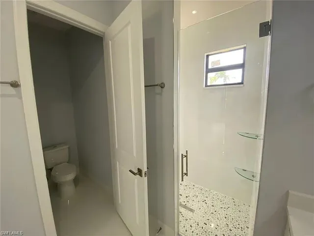 Bathroom featuring toilet and a stall shower
