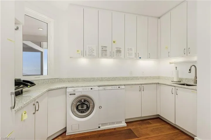 Laundry area featuring washer / dryer and dark wood-type flooring