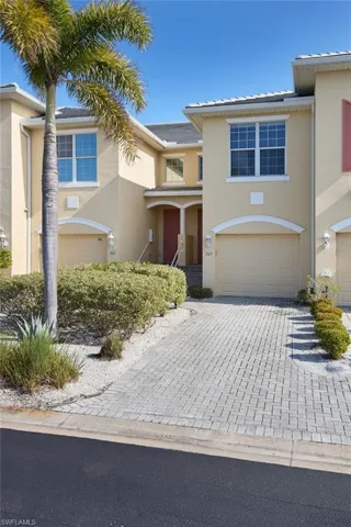 View of front of property featuring stucco siding, decorative driveway, and a garage