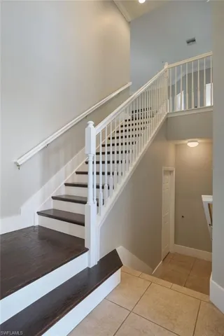 Stairway featuring a high ceiling and tile patterned flooring