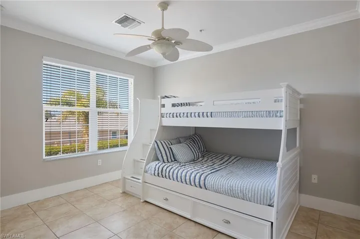 Bedroom featuring crown molding, light tile patterned floors, and a ceiling fan