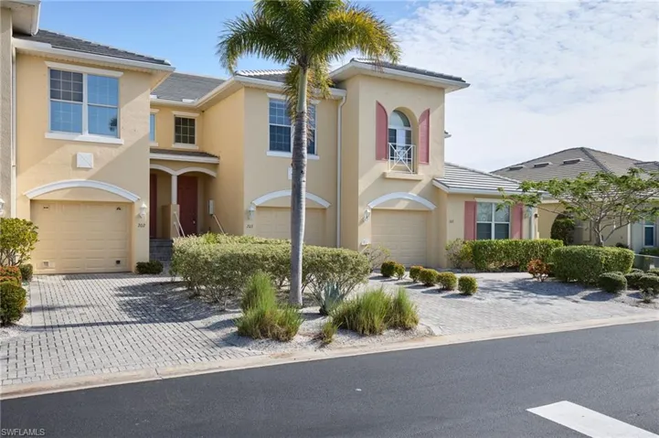 View of front of home featuring stucco siding, decorative driveway, and an attached garage