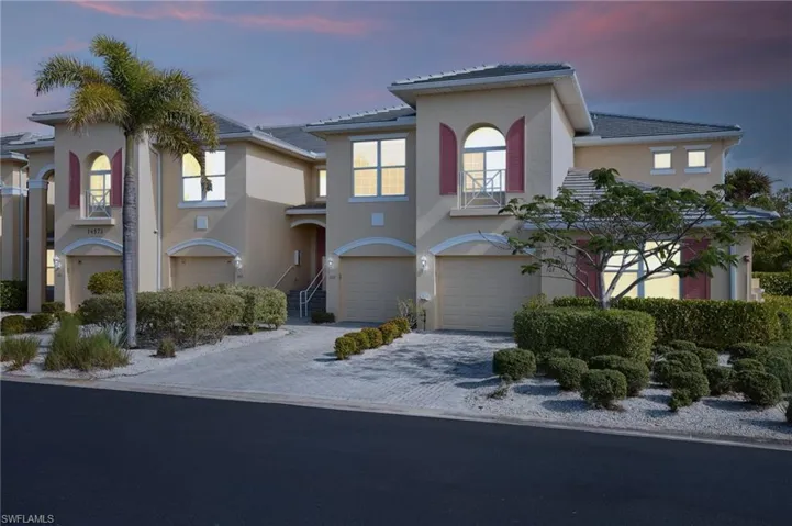 Mediterranean / spanish-style house with a garage, a balcony, stucco siding, and decorative driveway