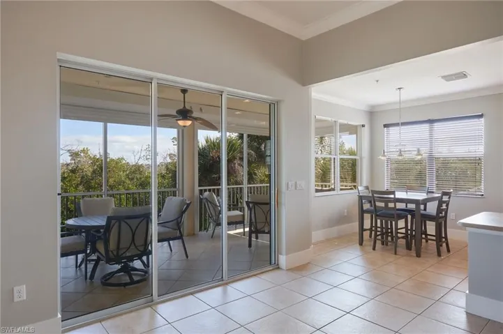 Dining area with ornamental molding, plenty of natural light, light tile patterned floors, and a ceiling fan