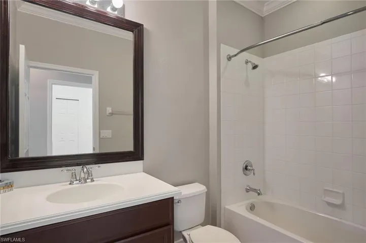 Full bathroom with shower / washtub combination, vanity, and crown molding