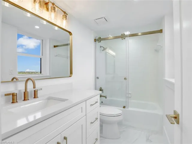 En-Suite Bath with tub/shower combo and glass barn-door slider.