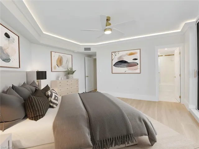 Bedroom with light wood-type flooring, connected bathroom, a ceiling fan, and baseboards