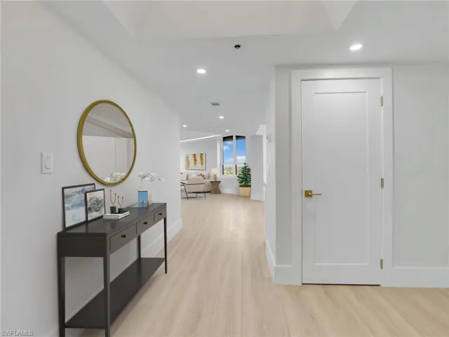 Hall with light wood finished floors, recessed lighting, and baseboards