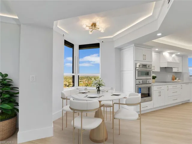 Dining space featuring light wood-style floors, healthy amount of natural light, baseboards, recessed lighting, and a tray ceiling