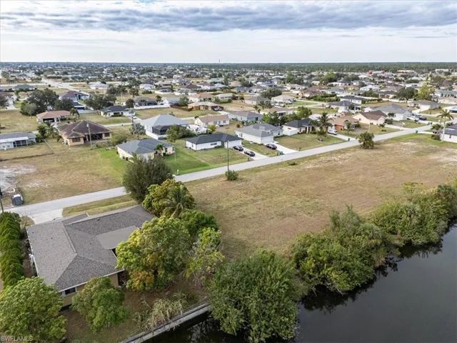 Birds eye view of property with a water view