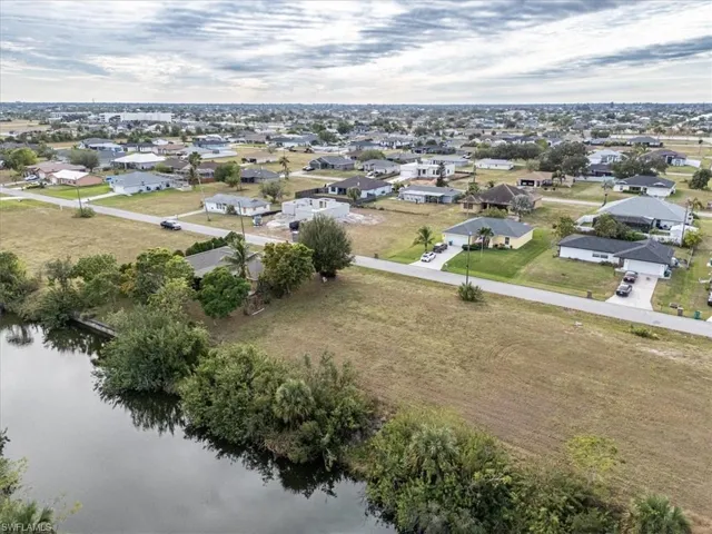Birds eye view of property with a water view