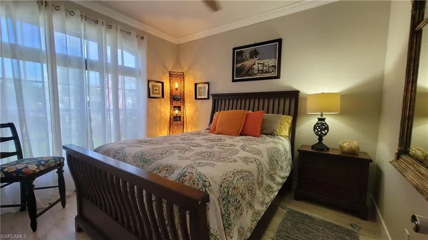 Bedroom with ornamental molding and hardwood / wood-style floors