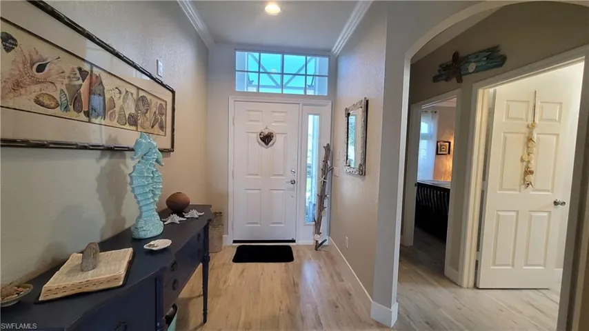 Foyer entrance featuring light hardwood / wood-style floors and ornamental molding