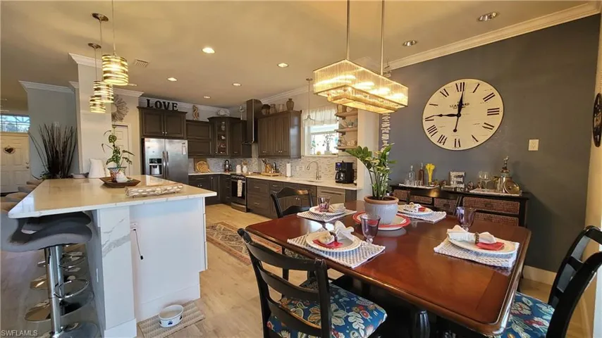 Dining area featuring crown molding, sink, and light wood-type flooring