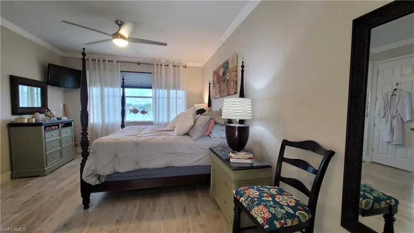 Bedroom featuring ceiling fan, light hardwood / wood-style floors, and crown molding
