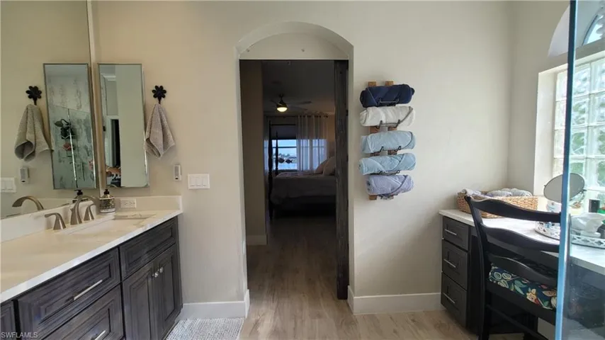 Bathroom featuring ceiling fan, vanity, and wood-type flooring