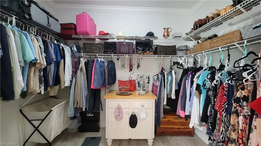 Walk in closet with light wood-type flooring
