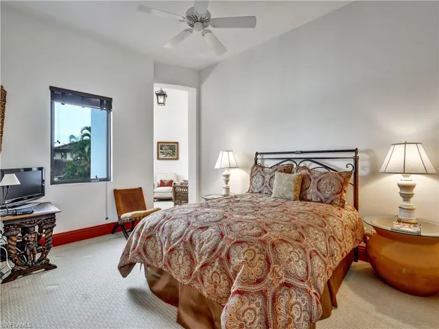 Bedroom featuring a window with exterior landscaping, a ceiling fan, and carpeted flooring