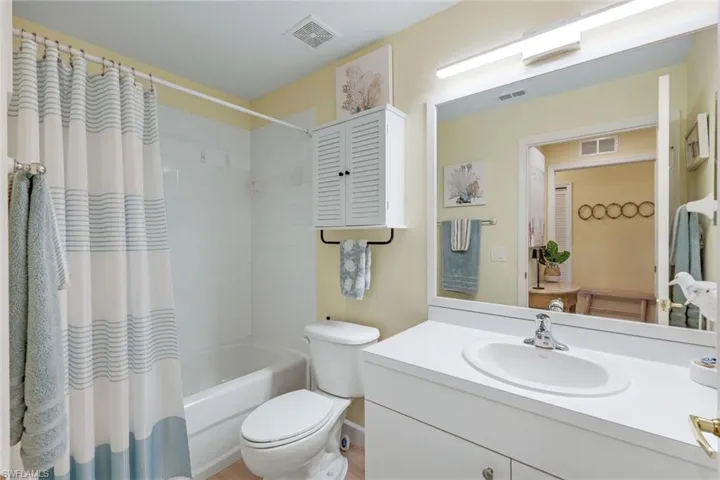 Full bath with visible vents, toilet, shower / tub combo, and vanity