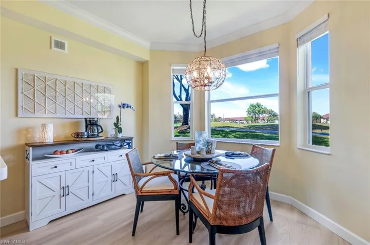 Dining space featuring visible vents, a chandelier, crown molding, light wood finished floors, and baseboards