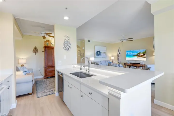 Kitchen with open floor plan, ceiling fan, a sink, and dishwasher
