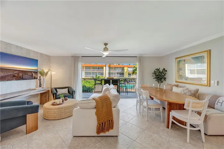 Living / Dining room with crown molding, ceiling fan, and light tile patterned flooring with view of pool area