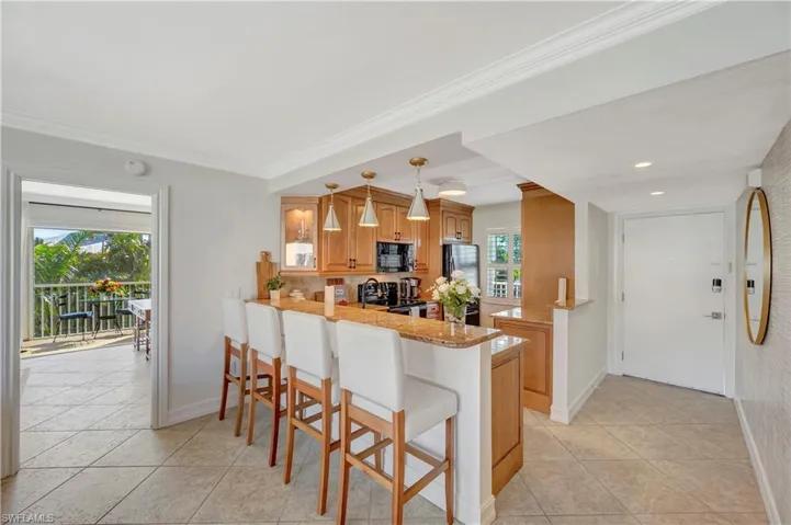 Kitchen featuring decorative light fixtures, a breakfast bar area, kitchen peninsula, and appliances