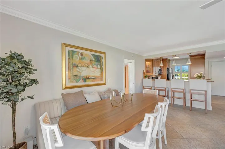 Tiled dining area featuring crown molding