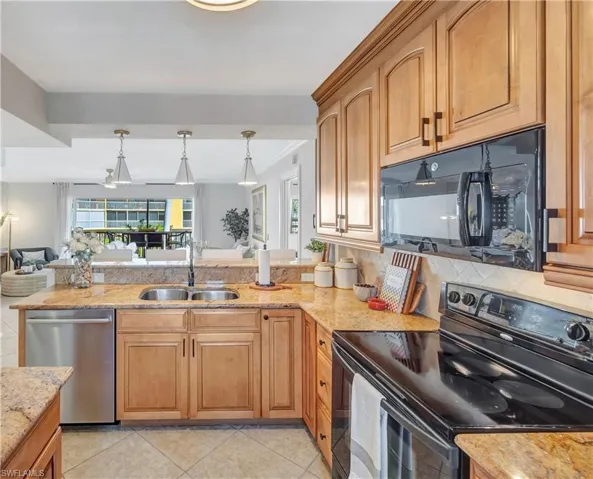 Kitchen with granite counters, sink, decorative light fixtures