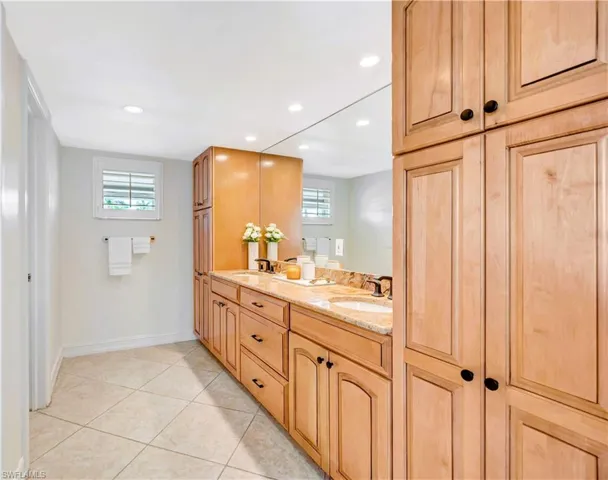Primary bathroom with dual vanity sinks, tile flooring