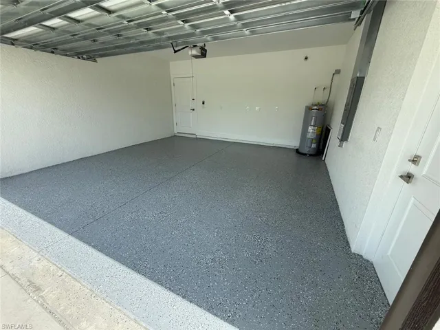 Garage featuring electric water heater and electric panel