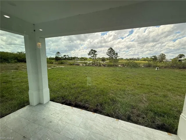 View of green lawn featuring a patio
