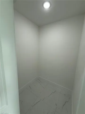 Unfurnished room with baseboards and light marble finish flooring