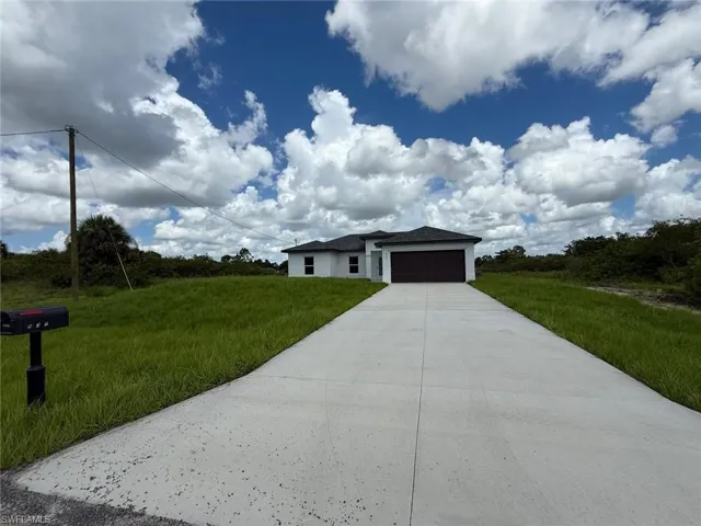 Prairie-style house featuring an attached garage, driveway, and a front yard