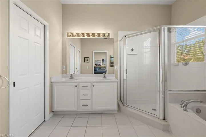 Bathroom featuring independent shower and bath, vanity, and tile patterned flooring