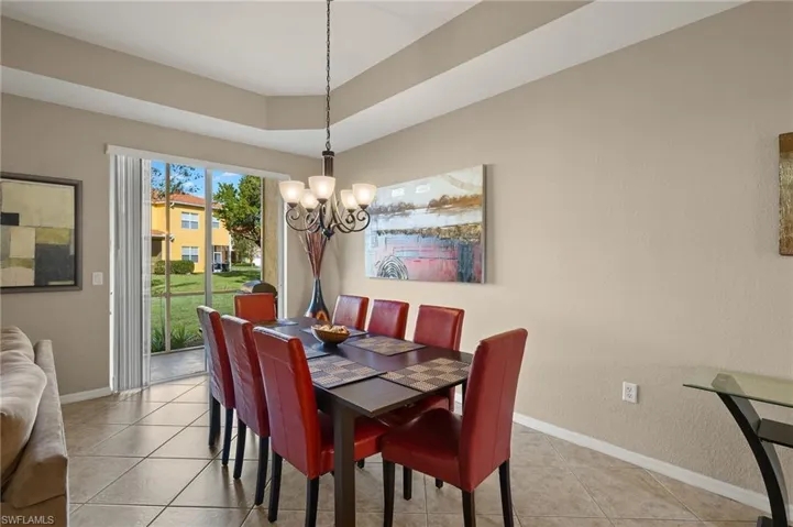 Tiled dining room featuring an inviting chandelier