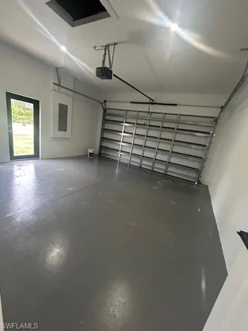 Garage featuring electric panel and a garage door opener